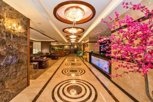 un vestíbulo de hotel con TV y flores en Dab Hotel, en Estambul