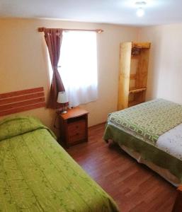 a bedroom with two twin beds and a window at Donde Lupe in Coihaique