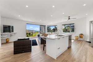 a kitchen with a sink and a living room at Paihia Paradise - Paihia Holiday Home in Paihia