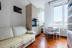 sala de estar con sofá, mesa y cocina en Nice and Cozy studio in Porta Romana by Easylife, en Milán