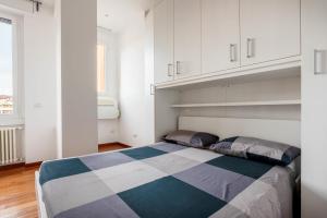 Schlafzimmer mit einem Bett und weißen Schränken in der Unterkunft Nice and Cozy studio in Porta Romana by Easylife in Mailand