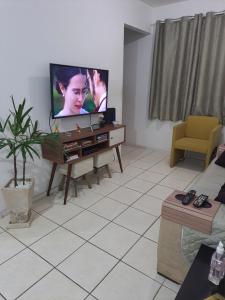 uma sala de estar com uma televisão de ecrã plano na parede em Casa em Condomínio no Rio de Janeiro