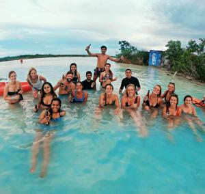 a number of people in a pool on a beach at The Yak Lake House - Hostal in Bacalar