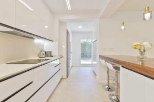a kitchen with white cabinets and a wooden counter top at Villa Marvelia in Marbella