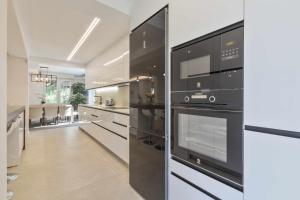 a large kitchen with black appliances and a hallway at Villa Marvelia in Marbella