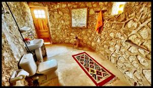 a stone bathroom with two sinks and two toilets at Al Nyhaya in Siwa