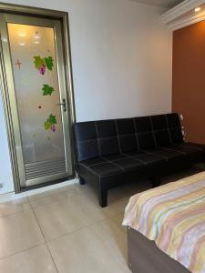 a black couch in a room with a sliding glass door at Sea View Holiday House in Hong Kong