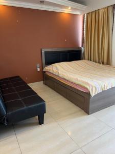 a bedroom with a bed and a black ottoman at Sea View Holiday House in Hong Kong