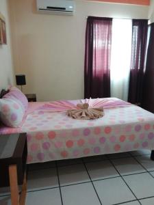 a bed with a polka dot sheet and a bow on it at Alme Hostel in Playa del Carmen