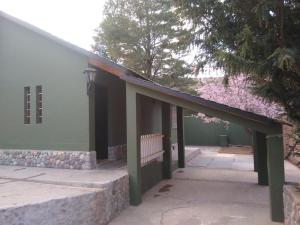 a building with a porch with a bench in front at Casa de montaña Manantiales-Nazareth in Potrerillos