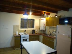 a kitchen with a white stove and a refrigerator at Casa de montaña Manantiales-Nazareth in Potrerillos