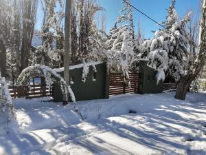 a snow covered yard with a fence and trees at Casa de montaña Manantiales-Nazareth in Potrerillos