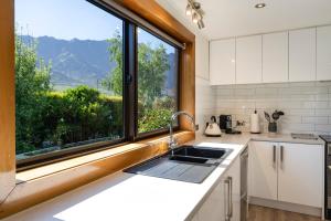 a kitchen with a sink and a large window at Remarkables View in Queenstown