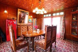 a dining room with a wooden table and chairs at Houseboat Lily of Nageen in Srinagar