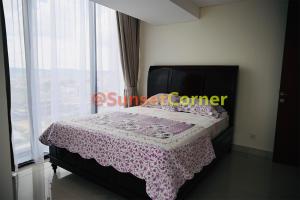 a bedroom with a bed with a pink blanket and a window at Sunset Corner @Pollux Habibie in Batam Center
