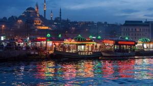 a group of boats docked on the water at night at Hotel Otağ in Istanbul