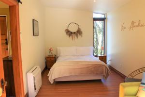 Schlafzimmer mit einem Bett und einem Spiegel an der Wand in der Unterkunft Misty River Retreat in Blenheim