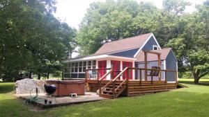 a small house with a deck and a hot tub at The Jive - Christophers_riverside_cabin in Luray