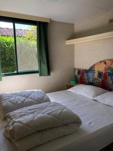 1 dormitorio con 2 camas y ventana en Zona Rosa 5 Chalet mit Klimaanlage und Wlan en Viareggio