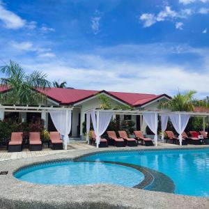 una piscina con sedie e un edificio di Garden Village Resort a Moalboal