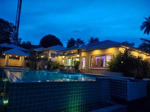 una casa con piscina por la noche en Baan Nai Daeng Villa /Baannaidaengvilla en Bophut 