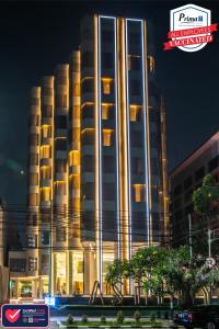 a large building with lights on in front of it at Ashley Wahid Hasyim Jakarta in Jakarta