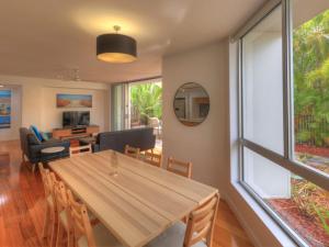 a dining room and living room with a wooden table at Maggies Beachfront Apartment 2 in Horseshoe Bay