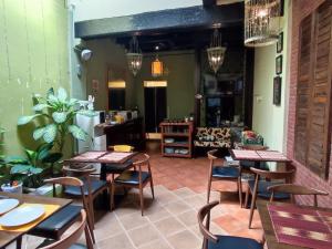 a restaurant with tables and chairs in a room at Cintra House Penang in George Town