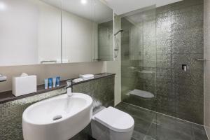 a bathroom with a sink and a toilet and a shower at Meriton Suites North Sydney in Sydney