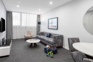 a living room with a couch and a table at Meriton Suites North Sydney in Sydney