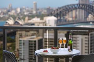 a table topped with plates of food and drinks at Meriton Suites North Sydney in Sydney