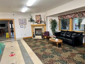 a living room with a black leather couch and a fireplace at Express Inn & suites in Decatur