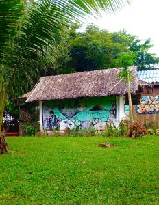 a building with a painting on it with a grass roof at Lazy Bones in Koh Rong Sanloem