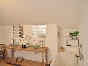 a bathroom with two bowls on a table next to a tub at Villa Sunset in La Saline les Bains +23 photos