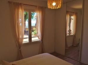 a bedroom with a bed and a mirror and a window at Villa Sunset in La Saline les Bains