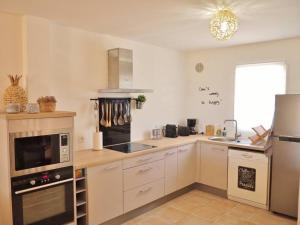 a kitchen with white cabinets and a stove top oven at Villa Sunset in La Saline les Bains