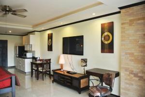 a living room with a couch and a tv on the wall at View Talay 5 studio apartment - close to the beach in Pattaya South
