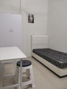 a white room with a bed and a table and stool at Color Mixed Home Hostel in George Town