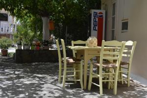 a yellow table and chairs sitting next to a building at Dimitra Hotel in Kamena Vourla