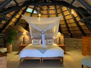 Kariba的住宿－Hornbill Lodge，一间卧室配有一张带蚊帐的床