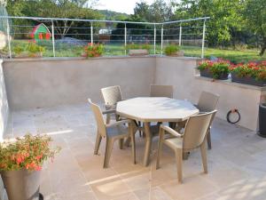 una mesa y sillas en un patio con flores en Gîte Senaide, 3 pièces, 5 personnes - FR-1-589-212, 