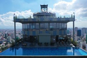 a building with a swimming pool on top of a city at The Penthouse Residence in Phnom Penh