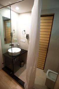 a bathroom with a sink and a shower with a mirror at Golden Sands Resort, Morjim in Morjim