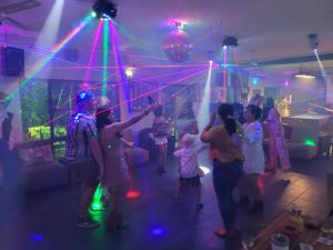 eine Gruppe von Leuten, die in einem Raum mit Lasern tanzen in der Unterkunft Cardwell at the Beach in Cardwell