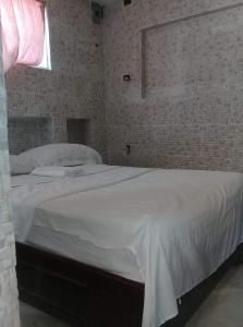 um quarto com uma grande cama branca e uma janela em Villa Julirous Rd spa and ApartHotel Camp for vacationers 2 bedrooms em Boca Chica