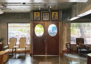 a large wooden door in a room with chairs at Niagara Hotel in Bangkok