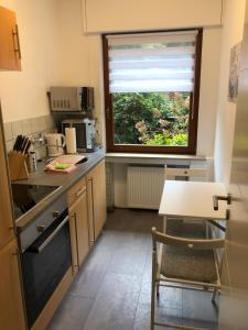 una pequeña cocina con mesa y ventana en Ferienwohnung Poppelreiter, en Solingen