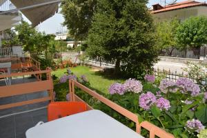 a garden with flowers and a table and chairs at Dimitra Hotel in Kamena Vourla