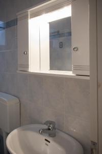 a bathroom with a sink and a mirror and a toilet at Dimitra Apartments in Kandia