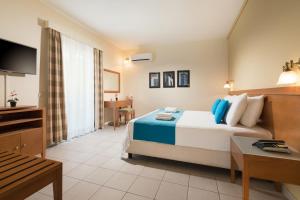 a hotel room with a bed and a table at Aeolian Village Beach Resort in Skala Eresou